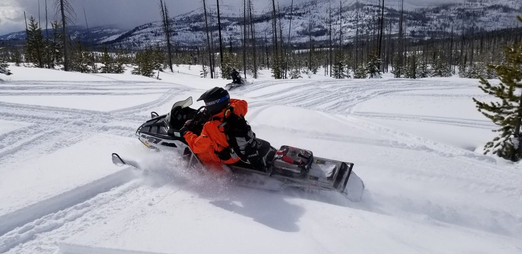 Snowmobiler turning in the mountains