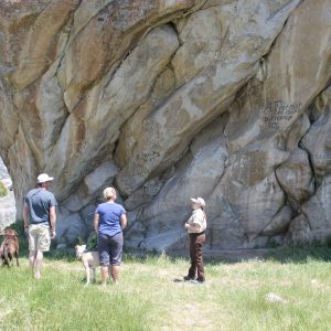 Park visitors looking at register rock, a large rock where emigrants sign on their travels
