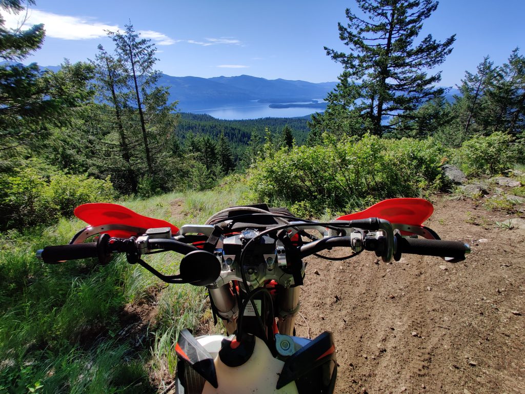 POV trail ranger on a motorcycle over looking a mountain scene from the trail 