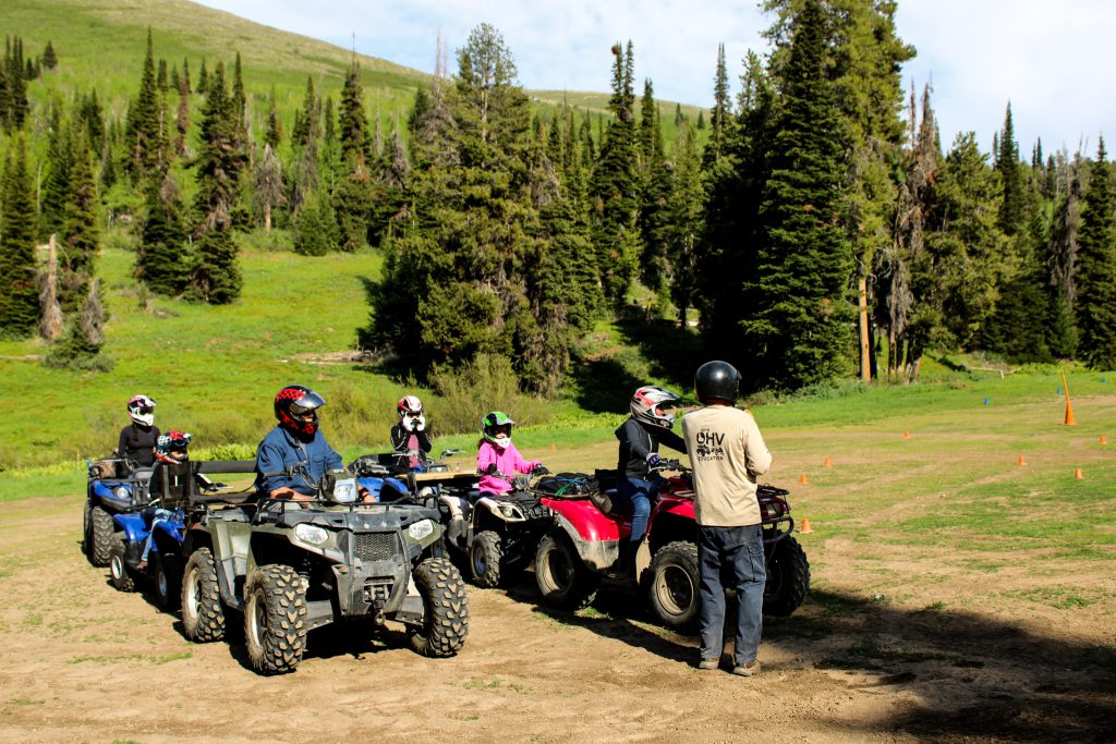 OHV riders and an instructor in a forested mountain setting