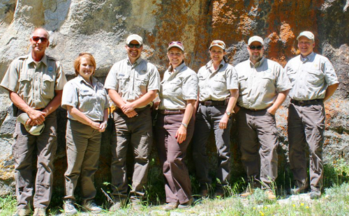 Parks and Recreation staff pictured in front of a large rock