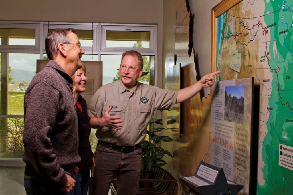 man showing guests large map on wall