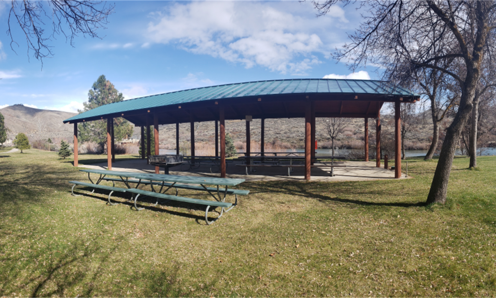 Upper Discovery Shelter, image of the empty shelter with the river in the background, mid fall with bare trees, blue sky day