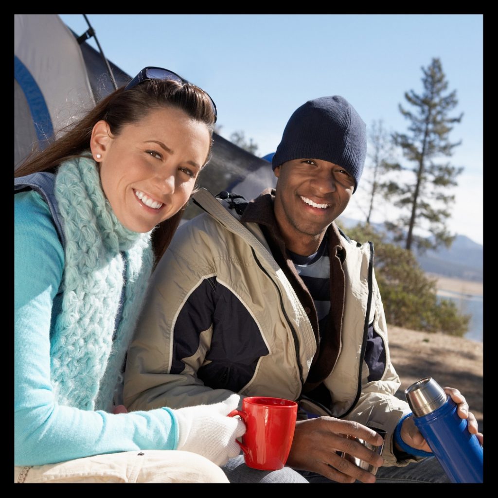 smiling man and woman by tent