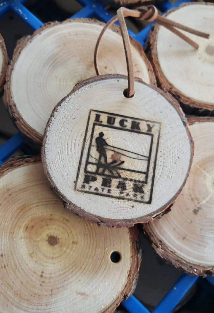 tree branch slice showing tree rings with the lucky peak state park logo branded on its surface